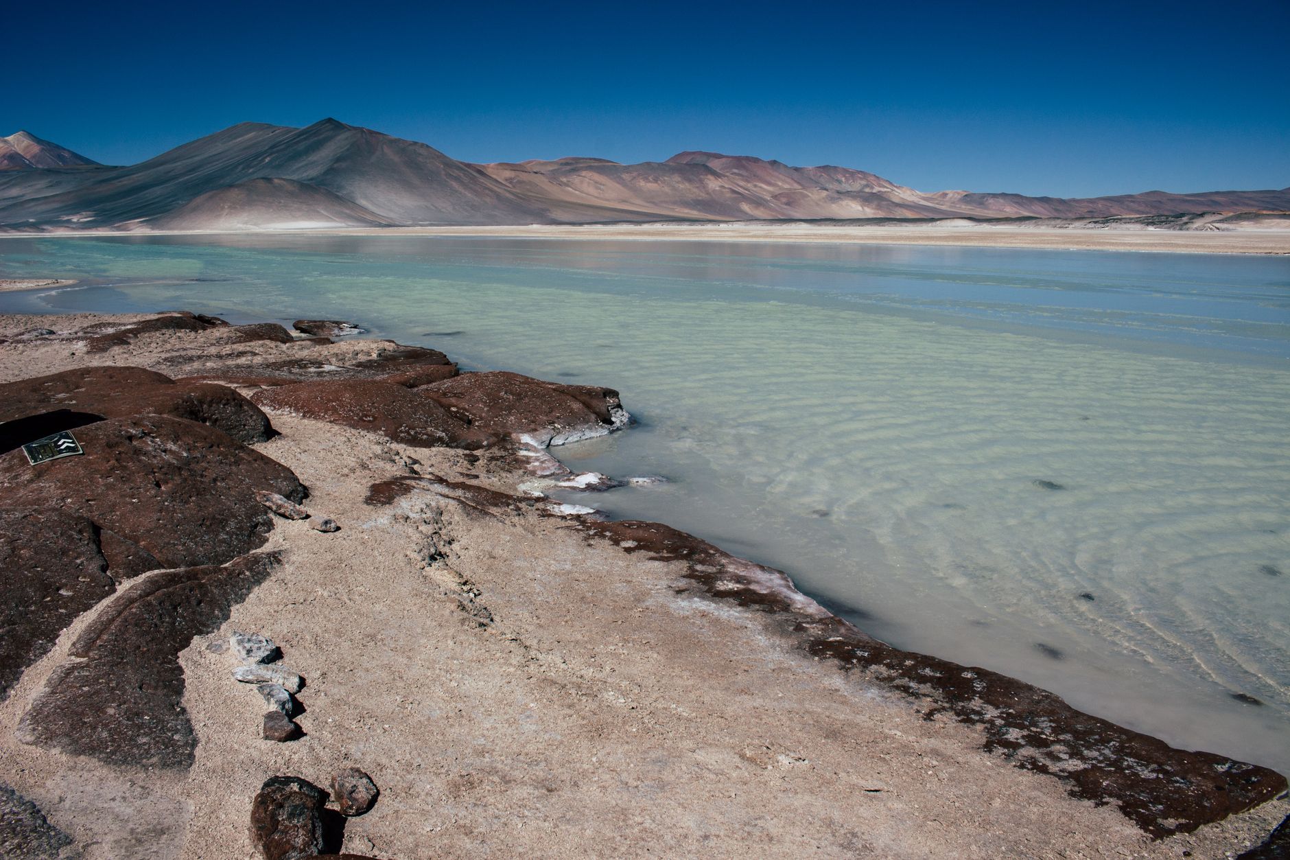 Desert sand and volcanic peaks under clear sky