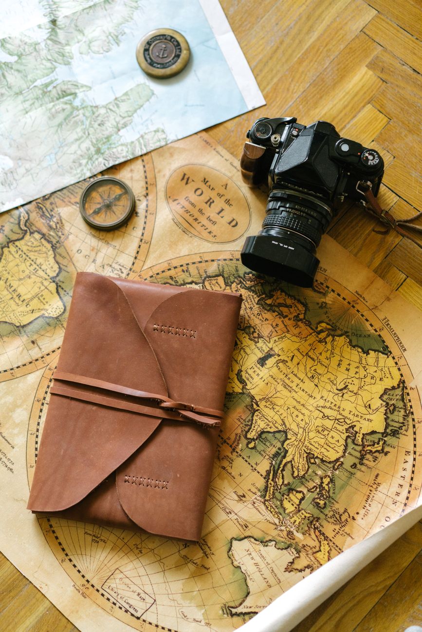 Luggage and journal prepared on wood table